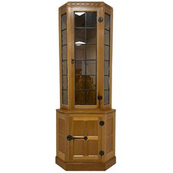 Mouseman - oak floor-standing corner cabinet, arcade carved cresting over lead glazed single door and uprights, the lower cupboard enclosed by panelled door with wrought metal fixtures, carved with mouse signature, on skirted base, by the workshop of Robert Thompson, Kilburn 