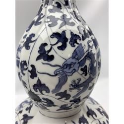 Mid 20th century Japanese lamp of lobed double gourd form, hand painted five claw dragons amidst clouds and foliage, with brass double light fitting and hardwood base, H60cm overall, together with a Japanese blue and white shell shaped dish (2)