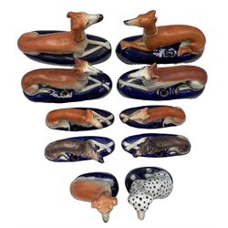 Group of 19th century Staffordshire inkwells, eight modelled as recumbent Greyhounds, two with sponged decoration, all on blue oval bases, two further inkwells modelled as a seated Greyhounds, together with a model of a seated Dalmatian, L16cm max (10)