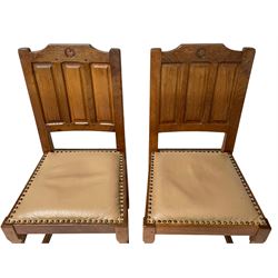 Wrenman - set four oak dining chairs, the cresting rail carved with wren signature over triple fielded panel back, leather upholstered seats with studwork, on carved octagonal front supports joined by plain stretchers, by Robert (Bob) Hunter of Thirlby, Thirsk