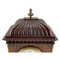 French – 19th- century 8-day Mahogany mantle clock with a carved pediment surmounted by a turned brass finial, flat top with a moulded cornice and carved frieze beneath, inlaid brass decoration to the corners, front and base, raised on bun feet, white enamel dial with Arabic numerals, minute markers and steel spade hands, enclosed within a convex glass and cast bezel, French square plated rack striking twin train movement, striking the hours and half hours on a coiled gong. With pendulum.