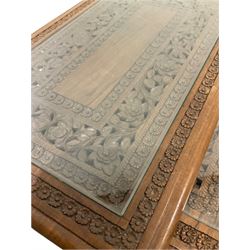 A nest of four Kashmiri tables, the rectangular top with carved foliate design and glass panel, small table fitted with one frieze drawer W52cm