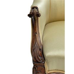 Victorian rosewood armchair, scroll carved arm terminals, the shaped uprights carved with foliage, upholstered in pale yellow fabric, on scroll carved cabriole supports with brass and ceramic castors, sprung seat