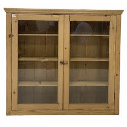 Early 20th century pine wall hanging kitchen cabinet, two glazed doors enclosing three shelves, tongue and groove back boards, W117cm, H116cm, D24cm