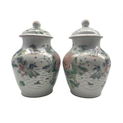 Pair of 19th century Chinese Qing dynasty vases and covers decorated with figures, lake landscapes, flowers and scrolls and with earlier Kangxi period marks H29cm 
