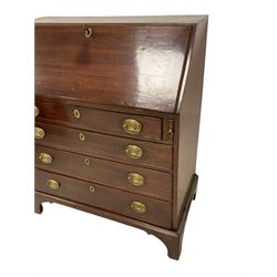 George III mahogany bureau, the fall-front enclosing fitted interior with later inlays, over four graduating cock-beaded drawers with pressed brass plates and drop handles, lower moulded edge over bracket feet