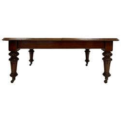 Early Victorian dining table, walnut rectangular moulded top with rounded corners, the base on turned supports carved with foliate and egg and dart decoration, brass and ceramic castors