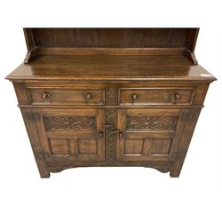 Georgian design oak dresser, two-tier plate rack with shaped aprons, the base fitted with two fielded moulded drawers, over two panelled cupboards carved with scrolling acanthus leaves, with guilloche carved central upright, on stile feet