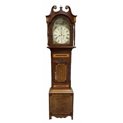 Mid-19th century oak and mahogany longcase clock with a swan neck pediment and brass patera with a short central brass finial, pediment inlaid with narrow vertical satinwood panels and stringing, glazed broken arch door flanked by part-ringed turned columns with brass capitals to the base, trunk with canted corners and two inlaid satinwood panels, applied radiating carving above the short oak door with inlay and wide mahogany banding, conforming inlay to plinth with shaped bracket feet, fully painted 13-inch-wide break arch dial with a white centre and gilt border, with roman numerals and minute track, subsidiary seconds dial and counter-clockwise calendar dial in Arabic’s, matching stamped brass hands and brass winding collets, corresponding scenes of ruined castles to the spandrels and a signed representation of Chepstow Castle in the arch, makers name indistinct, dial pinned via a steel false plate to a four pillar weight driven eight-day rack-striking movement with a recoil anchor escapement, striking the hours on a bell. With pendulum and weights. 