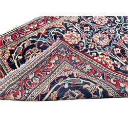 Persian crimson ground runner rug, the indigo field decorated with intertwining and scrolling foliate patterns with palmettes, the guarded border with repeating flower and plant motifs