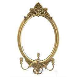 Late 19th century gilt wood and gesso framed wall mirror, anthemion pediment above oval mirror plate and three branch candle scone, 54cm x 89cm