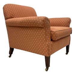 Howard & Sons - Edwardian mahogany framed armchair, traditional shape with rolled arms, upholstered in coral patterned fabric with sprung back and seat, with matching seat cushion, on square tapering supports with brass castors, the rear leg stamped '15881 5819 Howard & Sons Ltd Berners St'
Provenance: From the Estate of the late Dowager Lady St Oswald