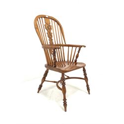 20th century yew and elm Windsor armchair, the hoop and spindle back with pierced and carved splat over saddle seat, raised on turned supports united by crinoline stretcher W58cm
