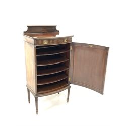 Maple & Co - Late 19th/ Early 20th century walnut bow front sheet music cabinet, raised back over cross banded and quarter sawn veneered top with moulded edge, one drawer over cupboard enclosing four sliding shelves, raised on turned fluted supports W55cm, H110cm