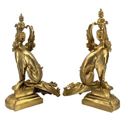 Pair of ornate gilt metal fire dogs in the form of Sphinxes, raised on scroll bases, H54cm