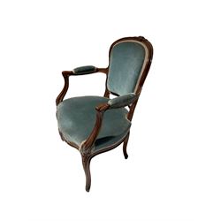 Early 20th century French style walnut open armchair, the moulded cresting rail carved with flower heads, upholstered in blue fabric, scroll carved arm terminals and cabriole supports