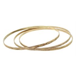 Three 9ct gold bangles with engraved decoration, all hallmarked