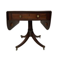 Regency mahogany drop-leaf supper table, rectangular top with rounded corners and ebony stringing, reeded edge, fitted with single cockbeaded oak lined drawer with brass handles and opposing faux drawer, raised on turned pedestal with quadripod base the splayed sabre supports terminating in brass cups and castors