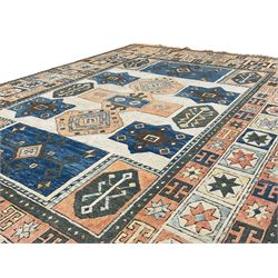 Antique Anatolian Turkish ivory ground carpet, field decorated with central peach geometric motif with surrounding stylised plant patterns within indigo borders, the multi-band border with repeating yildiz motifs