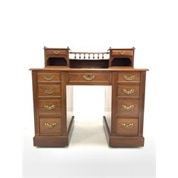 Maple & Co. - Edwardian walnut pedestal desk, the raised back with spindle gallery and open shelf to centre flanked by two trinket drawers, over tooled inset writing surface and one long and eight short graduated drawers, lock stamped 'Hobbs & Co' with makers plaque to centre drawer W107cm, H102cm, D63cm