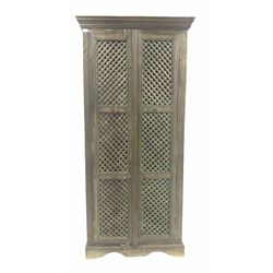 Indian painted hardwood cupboard, the lattice panelled doors enclosing two shelves, raised on shaped plinth base W86cm, H185cm, D37cm