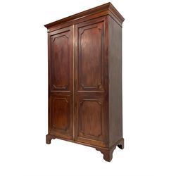 George III design mahogany double wardrobe, projecting cornice and banded frieze, two panelled doors enclosing hanging rail, on bracket feet