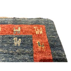 Small Persian Gabbeh indigo ground rug, comprised of three blue and red concentric squares, decorated with stylised camel motifs, retailed by Fired Earth
