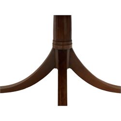 Georgian design mahogany dining table, the circular top with reeded edge, the pedestal carved with stepped turns terminating in a quadrupod base, the splayed sabre supports culminating in brass cups and castors