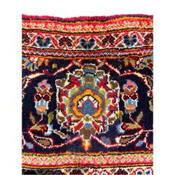 Small Persian Kashan red ground rug, central indigo blue ground medallion and spandrels, all-over floral design, the field decorated with interlacing foliage and stylised flower heads, multi-band border with repeating design decorated with plant motifs