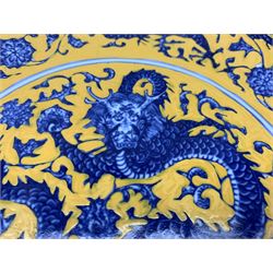 Chinese export charger in blue and white decorated with dragons and edged with border containing foliate design, overpainted in yellow with six figure mark to base D30cm