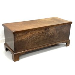 Early 20th century oak blanket box, hinged lid revealing interior fitted with four trinket drawers and candle tray, raised on shaped bracket supports W125cm, H52cm, D50cm
