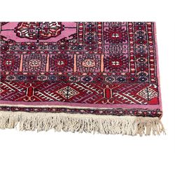 Persian Bokhara violet ground rug, the field with a row of eight Gul motifs surrounded by a heavily guarded border containing repeating geometric designs