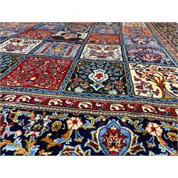 Persian Bakhtiari indigo ground garden rug, the field decorated with four rows of panels each depicting contrasting scenes of urns, trees of life, decorative pillars, Boteh motifs and birds of paradise, the palmette decorated indigo border guarded by crimson bands with repeating Boteh motifs