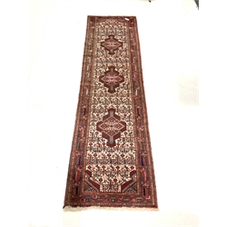 Iranian  red ground runner, triple medallion on pale field decorated with repeating motifs 