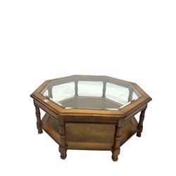 20th century hardwood octagonal coffee table, the top inset with bevelled glass, raised on turned supports united by under tier 
