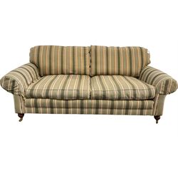 Traditional three seater sofa, with loose cushions upholstered in striped fabric, raised on turned supports terminating in brass castors W210cm