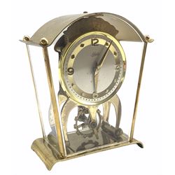 A vintage Schatz & Sohne German eight-day mantle clock with visible oscillating balance, integral key, white dial with gilt chapter ring, Arabic numerals at twelve, three, six, and nine, interspersed with lozenge hour markers, brass pressed bezel, gilt baton hands.