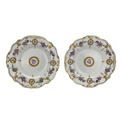 Pair of 19th/ early 20th century cabinet plates (1891- 1912), centrally painted roses within a raised greek key gilt roundel, the border painted with floral swags and further roundels, withinn shaped acanthus leaf moulded borders, pattern no. G7427, D23cm