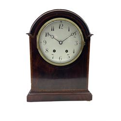 
An Edwardian mahogany mantle clock with a break arch top, inlaid satinwood stringing and banding, case on a moulded plinth raised on four bun feet, with a French eight-day movement striking the hours and half hours on a coiled gong, square movement plates stamped “B.T.G Medaille d'or”, six-inch enamel dial with upright Arabic numerals and minute markers, quarter hours in red Arabic's, with steel moon hands, cast brass dial bezel with a convex glass, brass case door with pierced sound fret. With pendulum and key.