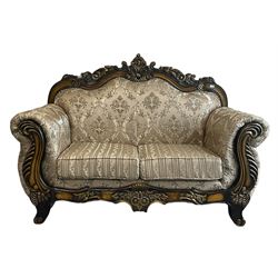 Italian Baroque design two seat sofa, hardwood framed, the cresting rail carved and pierced with c-scrolls and flower heads, scrolled arms, upholstered in floral patterned and striped fabric, with scatter cushions 