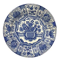 18th century Delft charger, possibly German, decorated in blue and white with a centre Chinese vase, the border with panels of flowers, leaves and symbols D40cm