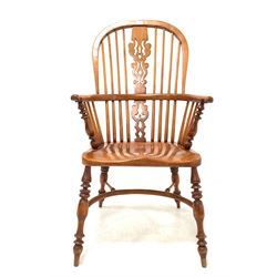 20th century yew and elm Windsor armchair, the hoop and spindle back with pierced and carved splat over saddle seat, raised on turned supports united by crinoline stretcher W58cm