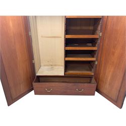 Large George III mahogany wardrobe, two panelled doors enclosing handing rail and five sliding trays, over deep single drawer with brass pull handles, on plinth base