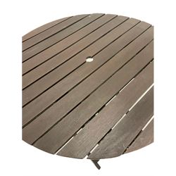 Stained hardwood garden table, the circular slatted top raised on a folding base (D90cm) together with a similar folding garden chair (W50cm)