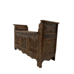 Oak window seat with hinged lifting seat over base with carved Gothic style arches 