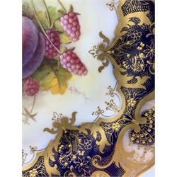 Royal Worcester hand painted cabinet plate by Albert Shuck c1925, centrally decorated with plums and raspberries against a cobalt blue ground with gilt highlights and raised gilt details to the border, D23.5cm