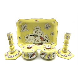 19th Century Berlin inkstand painted with panels of birds and insects on a yellow ground with inkwell and caster 25cm x 19cm (seconds leaf mark) and a pair of yellow ground candlesticks painted with landscape and floral panels on an hexagonal base H13cm with crossed swords mark