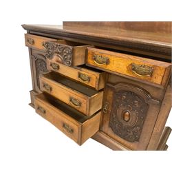 Edwardian walnut and oak sideboard, raised back with dentil carving and central shell motif, fitted with six assorted drawers and two flanking cupboards, the panelled facias carved with cartouche shields and scrolling foliage, on bracket feet