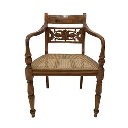 Hardwood elbow chair, carved rail back, open arms, cane seat panel, raised on reeded turned supports W57cm
