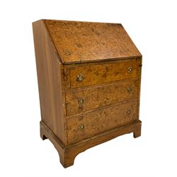 Figured walnut bureau, the fall front enclosing pigeon holes, fitted with three drawers, on bracket feet
